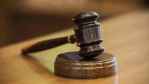 Wooden gavel resting on a judge's bench.